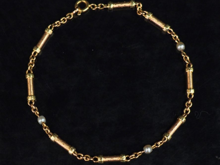 Bracelet articulé deux tons d'or, composé de maillons cylindriques à d