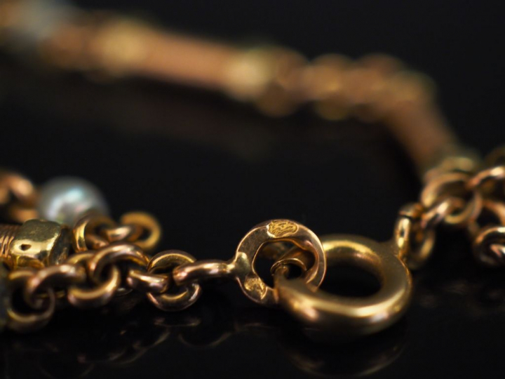 Bracelet articulé deux tons d'or, composé de maillons cylindriques à d