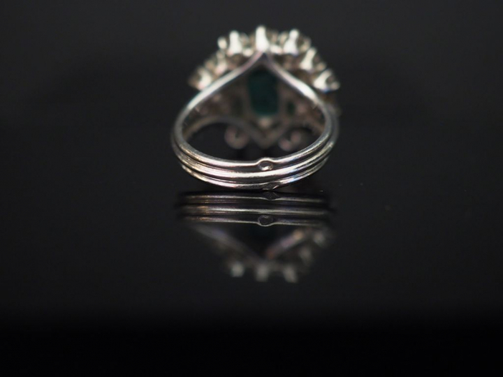 Bague marguerite en or blanc, sertie en son centre d’une émeraude ento