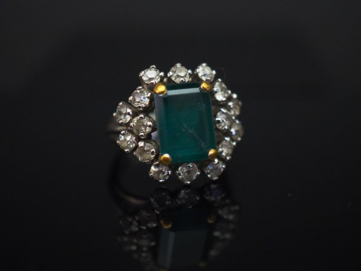 Bague marguerite en or blanc, sertie en son centre d’une émeraude ento