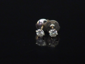 Vente aux enchères 	Paire de puces d’oreilles en or blanc, serties d’un diamant.  Système
