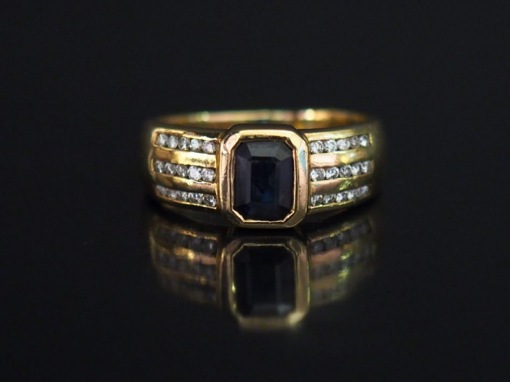 Bague jonc en or jaune, sertie en son centre d'un saphir épaulé de six