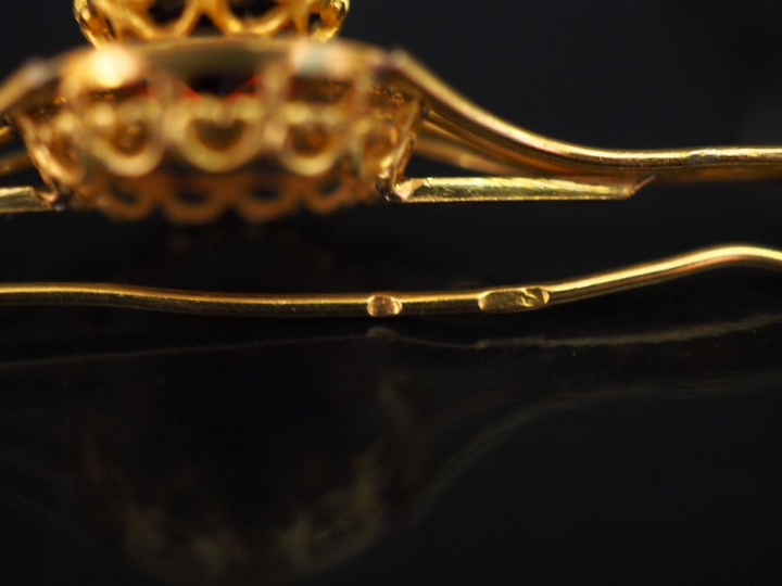 Parure en or jaune et pierres rouges, à décor filigrané. Comprenant : 