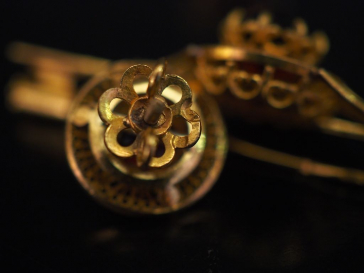 Parure en or jaune et pierres rouges, à décor filigrané. Comprenant : 