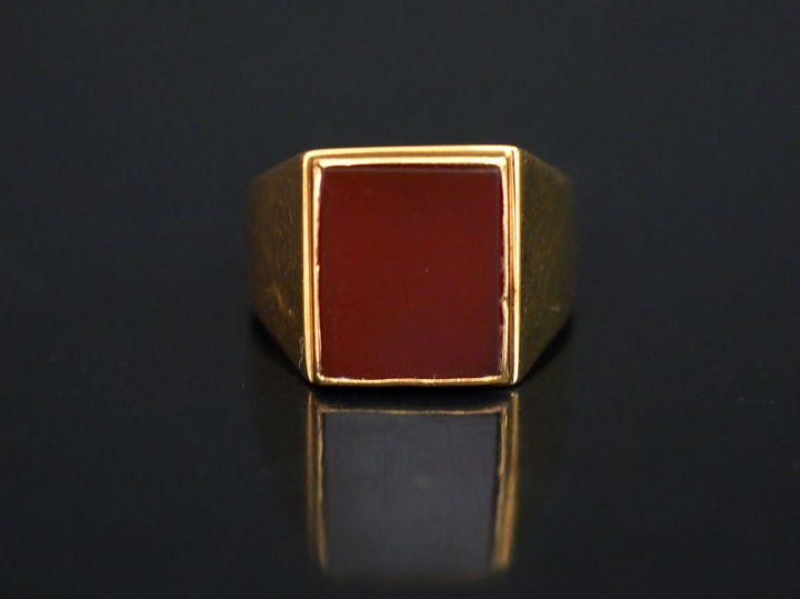 Bague de forme chevalière en or jaune, sertie en son centre d'une pier