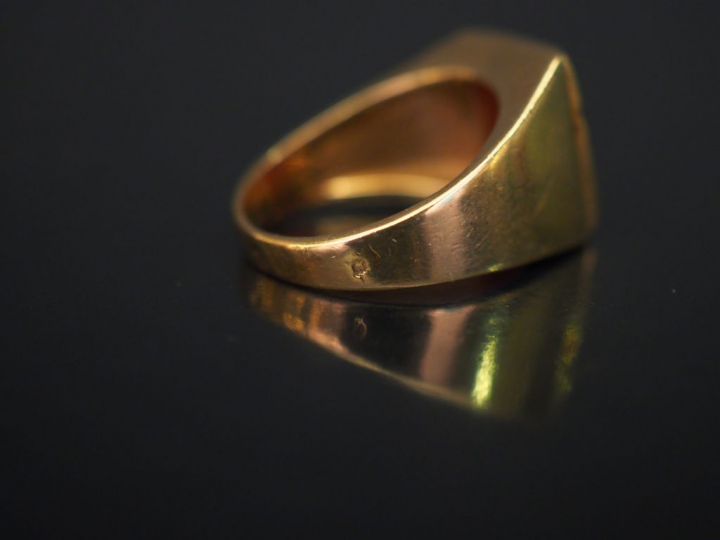 Bague de forme chevalière en or jaune, sertie en son centre d'une pier