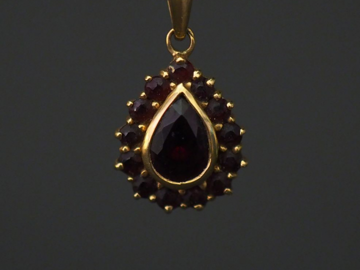 	Pendentif en forme de goutte en or jaune, serti en son centre d’un gr