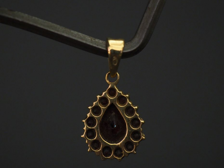 	Pendentif en forme de goutte en or jaune, serti en son centre d’un gr