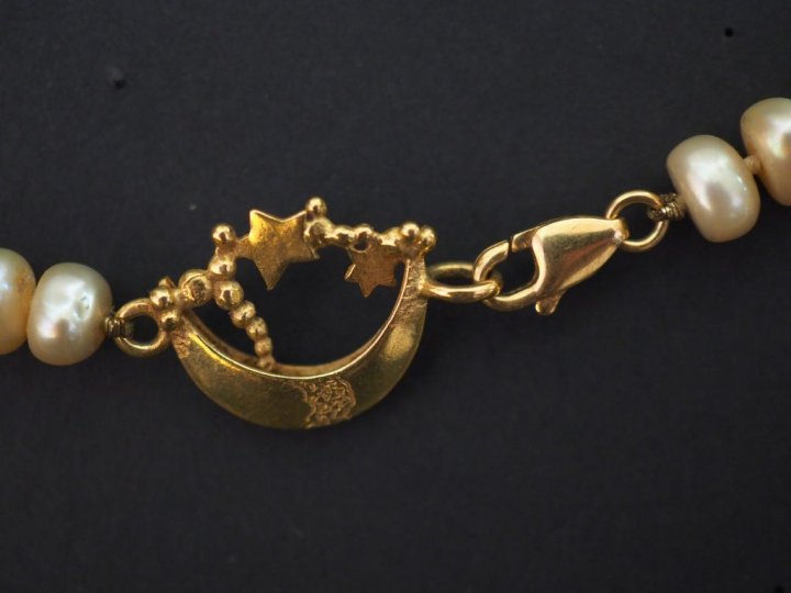 Collier de perles d'eau douce plates. Le collier est agrémenté de dix 