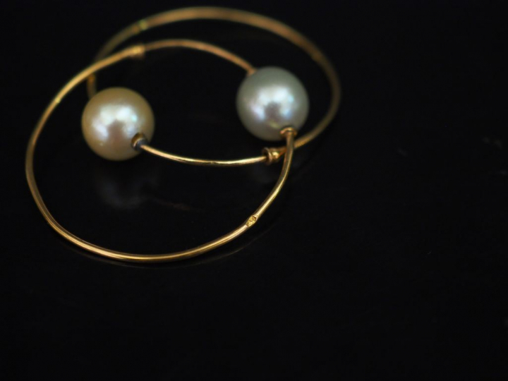 Paire de créoles en or jaune, agrémentées d'une perle. Diam. 2,7 cm  P