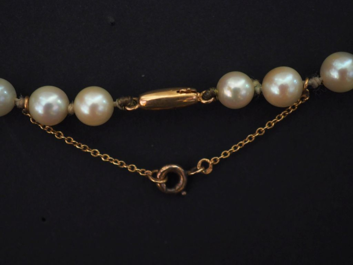 Sautoir en perles de culture blanches.  Fermoir en or jaune.  Chainett