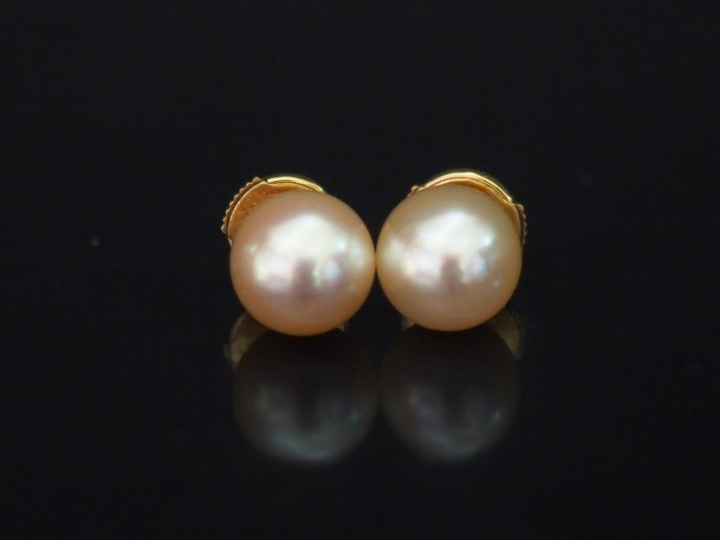 	Paire de perces oreilles en or jaune, serties d’une perle blanche. Sy