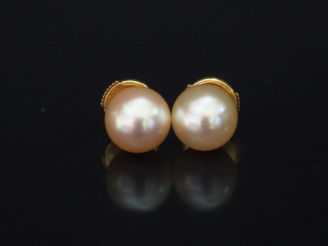 Vente aux enchères 	Paire de perces oreilles en or jaune, serties d’une perle blanche. Sy
