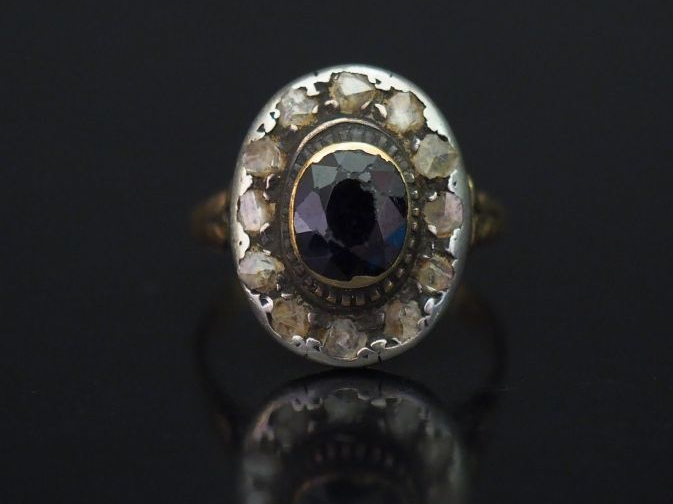 	Bague de forme marguerite en or jaune, sertie d’une pierre bleue ento