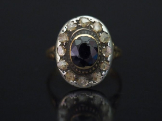 Vente aux enchères 	Bague de forme marguerite en or jaune, sertie d’une pierre bleue ento