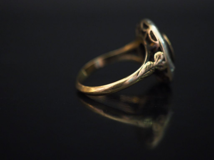 	Bague de forme marguerite en or jaune, sertie d’une pierre bleue ento