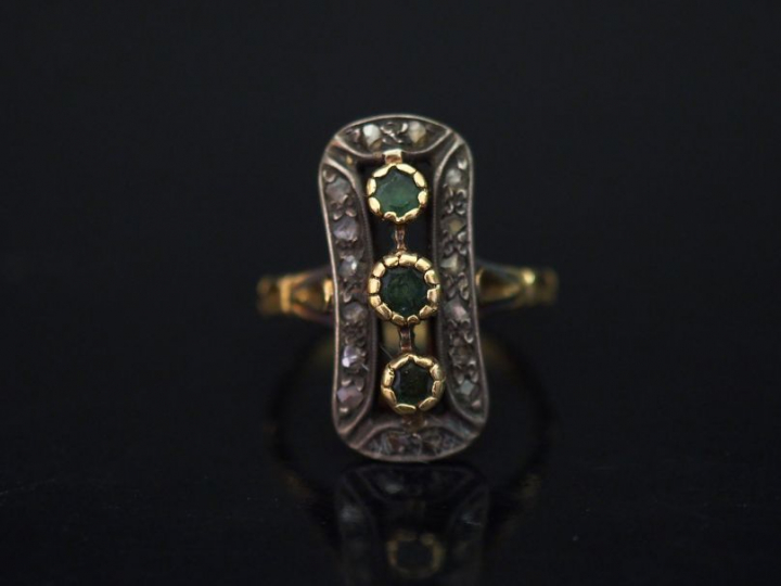 	Bague marquise en or jaune, sertie d’une ligne de trois pierres verte