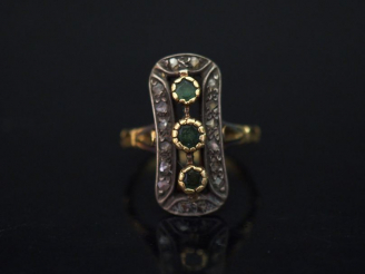 Vente aux enchères 	Bague marquise en or jaune, sertie d’une ligne de trois pierres verte