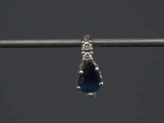 Vente aux enchères Pendentif en or blanc, serti d'un saphir en forme de goutte, surmonté 