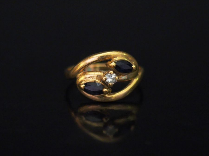 	Bague de forme stylisée en or jaune, sertie de deux pierres bleues en