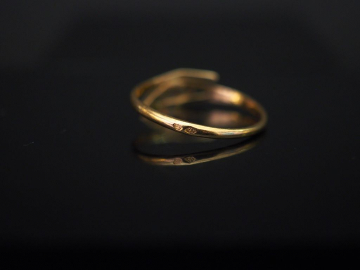 	Petite bague en or jaune de forme stylisée, sertie en son centre d’un