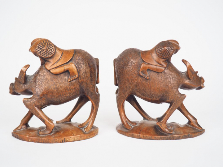 Paire de sculptures en bois "enfants sur des mufles montrant des bouvi