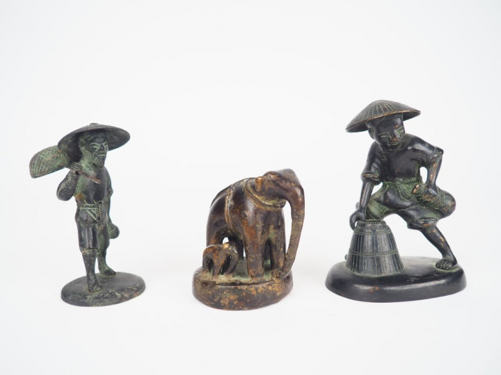 Trois sujets en bronze représentant un éléphant, son petit et un porte
