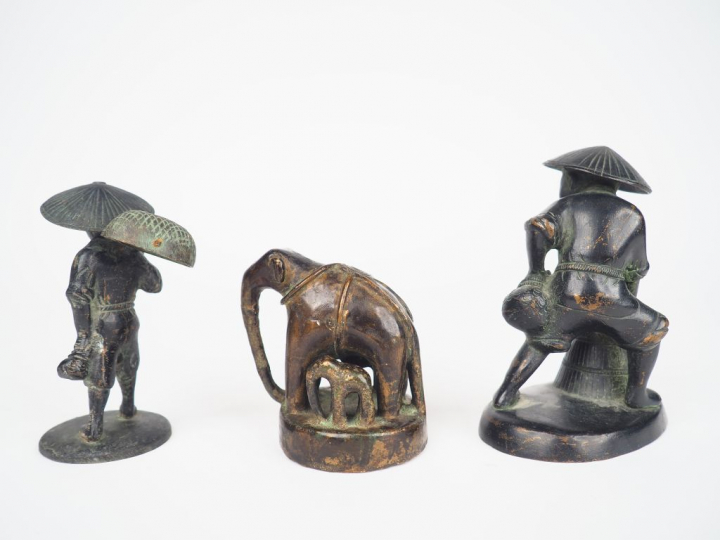 Trois sujets en bronze représentant un éléphant, son petit et un porte