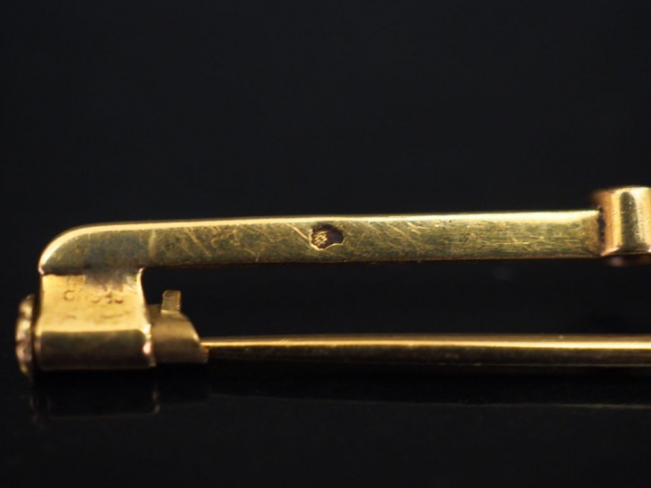Broche barrette en or jaune, sertie en son centre d'une opale épaulée 