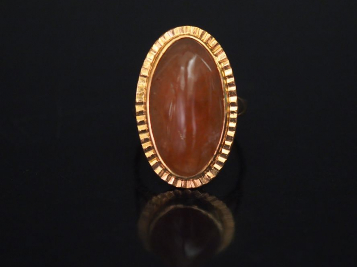 Bague en or jaune de forme ovale, sertie en son centre d'une pierre du