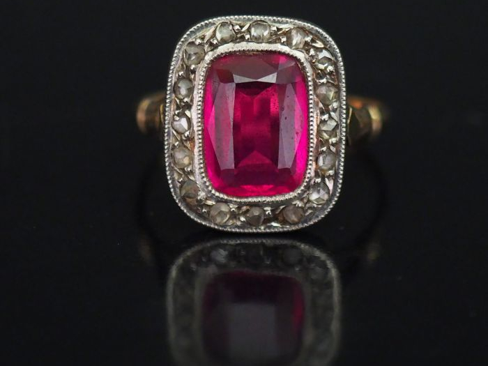Bague en or jaune, sertie en son centre d’une pierre synthétique rose 