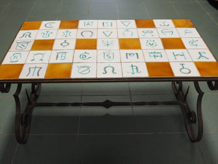 Table basse, plateau en céramique à décor de fers de manadiers. Dim. 4