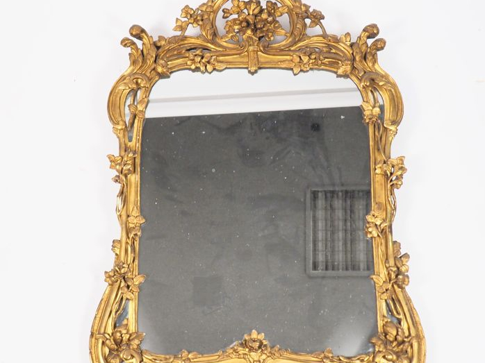 Glace Louis XV en bois sculpté et doré à décor de fleurs, de rocailles