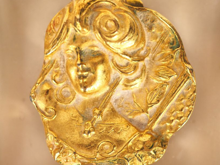 ESTEE LAUDER'S. Pot à fard en métal doré à décor d'élégante, dons son 