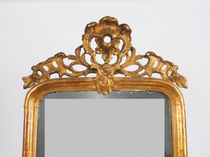 Miroir de style Régence en bois sculpté et doré, à décor de rocaille, 