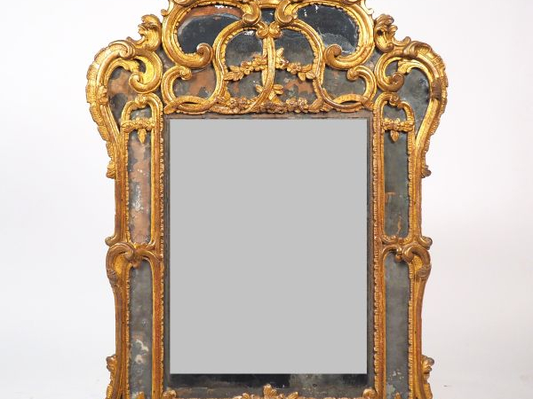 Glace XVIIIème à parecloses en bois sculpté et doré, à décor de rincea