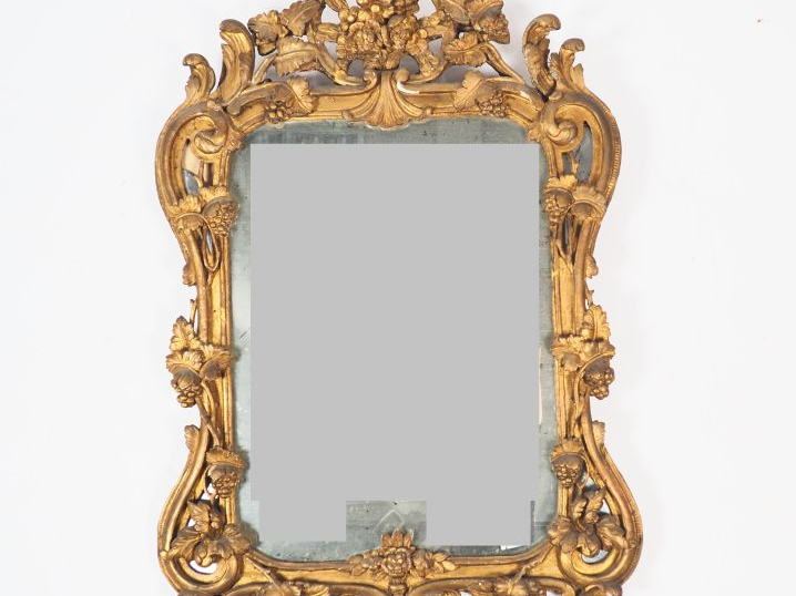 Miroir à parecloses Louis XV en bois et stuc doré, à décor de rinceaux