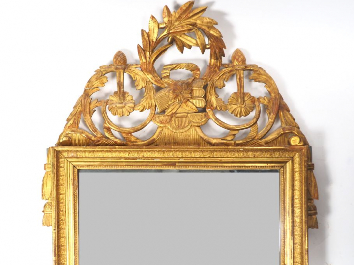 Miroir de style Louis XVI en bois et stuc doré, fronton ajouré à décor