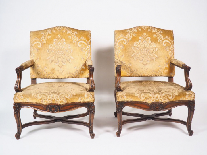 Paire de fauteuils de style Régence en noyer mouluré et sculpté, accot