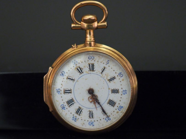 Montre de col en or jaune.  Cadran rond à chiffres romains pour les he