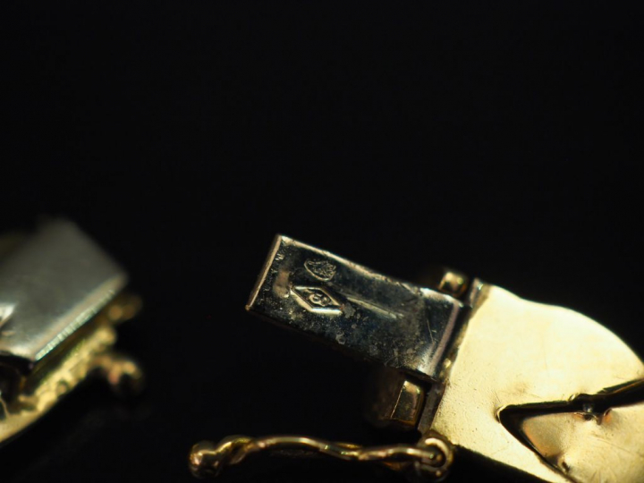 Bracelet articulé trois tons d’or, à décor de frise de feuillage. Long