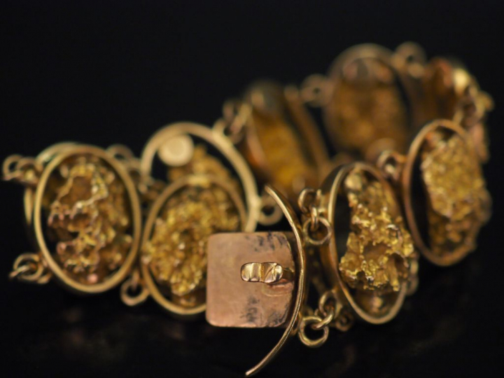 Bracelet articulé en or jaune, composé de neuf maillons ovales, sertis