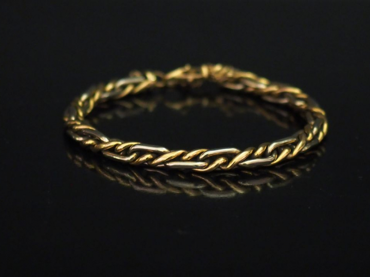 Bracelet souple deux tons d'or, maille tressée.  Chainette de sécurité