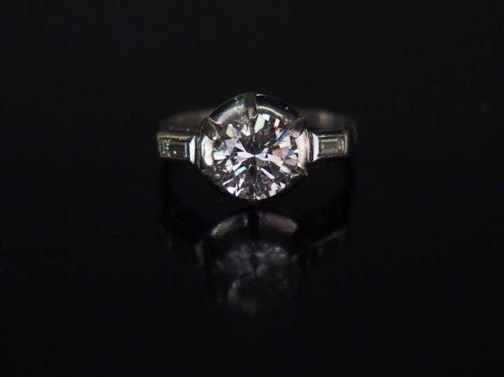	Bague de style Art déco en platine, sertie en son centre d’un diamant