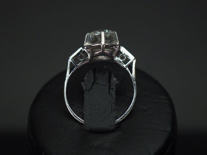 	Bague de style Art déco en platine, sertie en son centre d’un diamant