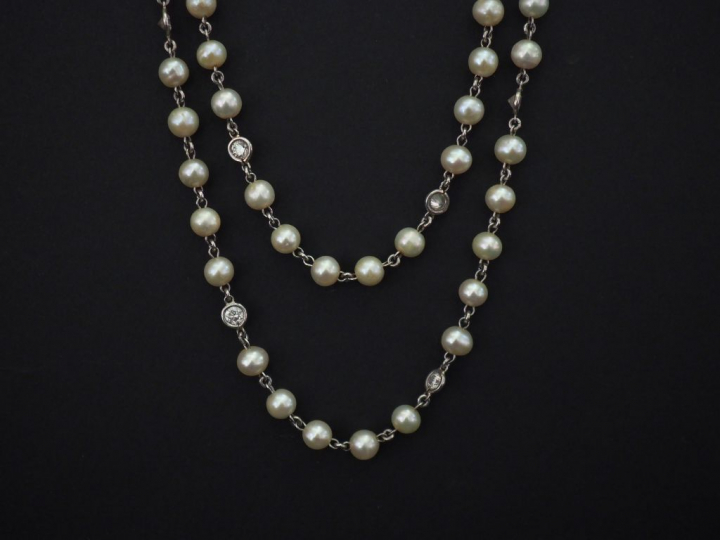 Sautoir en or blanc, composé de perles blanches et diamants alternés. 
