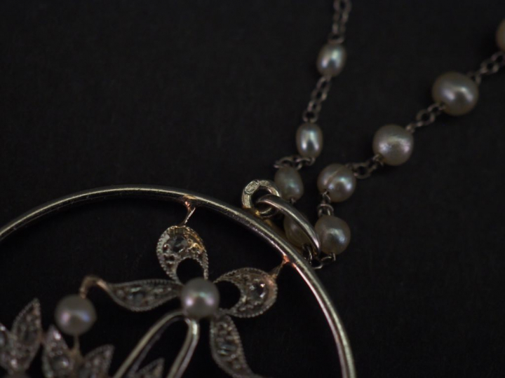 Chaine en or blanc agrémenté de perles blanches en chute, et pendentif