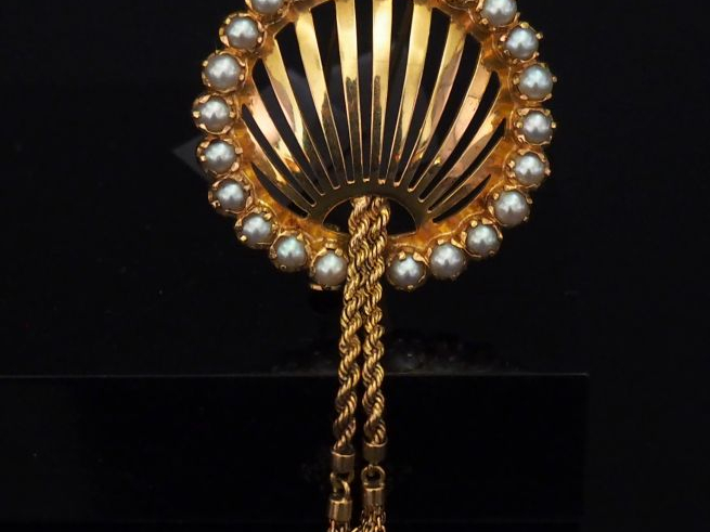 Broche ajourée en or jaune, à décor de deux pompons en pendeloques et 
