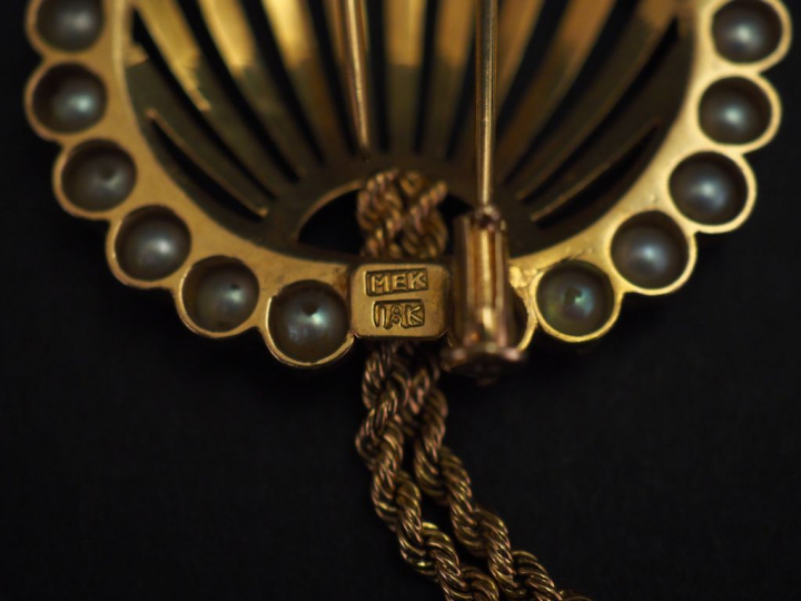 Broche ajourée en or jaune, à décor de deux pompons en pendeloques et 