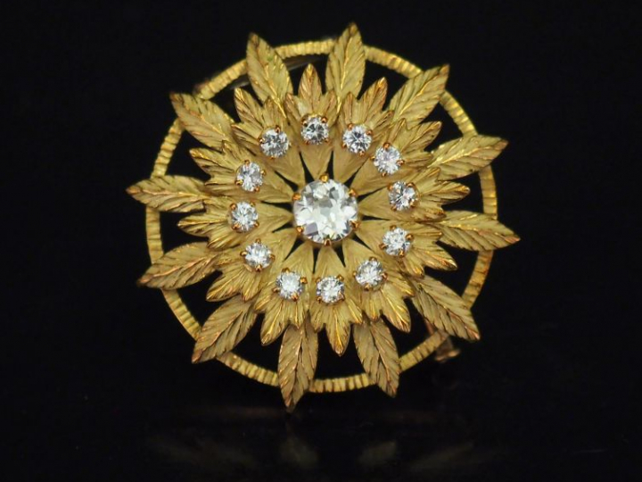 Broche ronde en or jaune, en forme de fleur épanouie, sertie en son ce